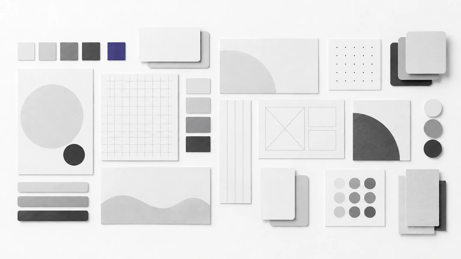 Overhead flat-lay of neatly arranged blank paper cards, wireframe tiles and colour swatch chips